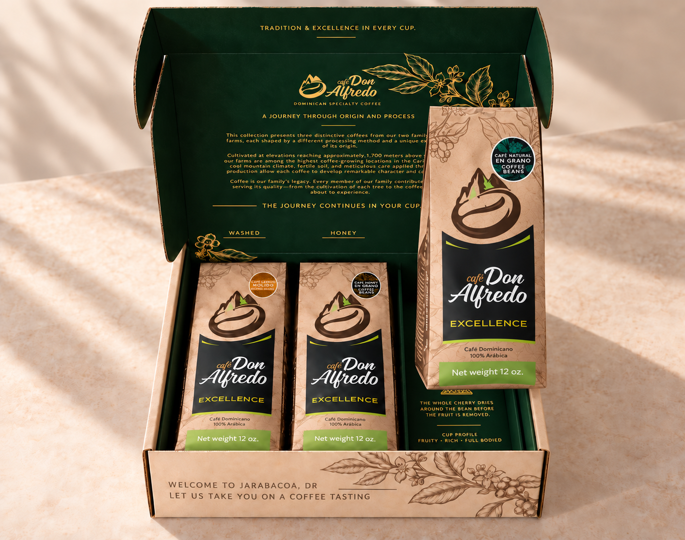An open Don Alfredo coffee gift box displayed on a beige fabric surface. The box contains three Don Alfredo Excellence coffee bags, with the dark green inner lid showing detailed product information and branding.